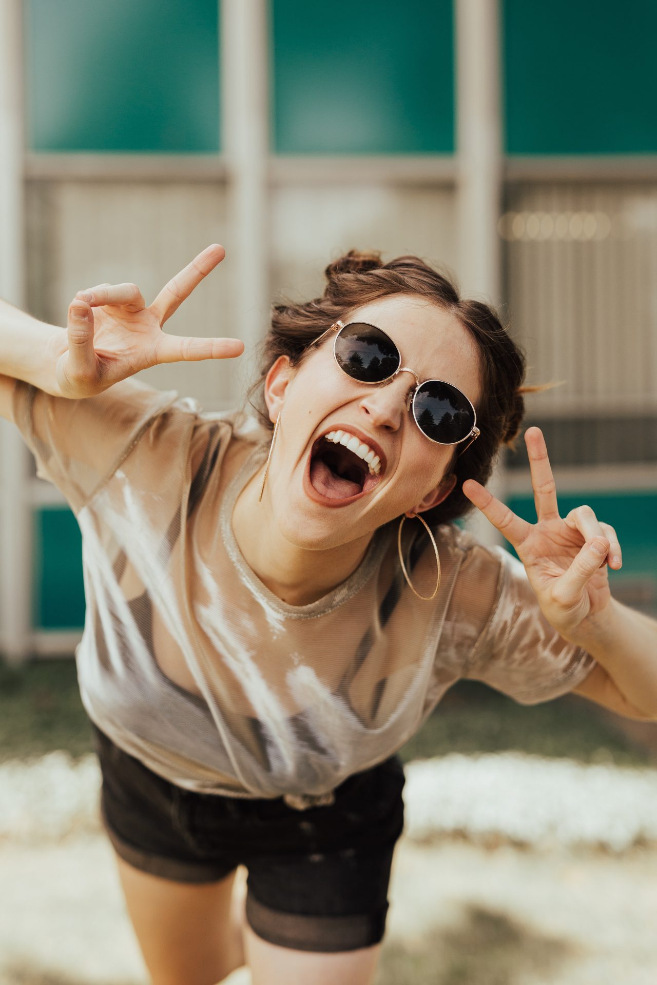 girl holding up the peace sign and smiling